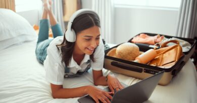 Computer travel and woman packing for a vacation with headphones typing a holiday blog. Adventure,