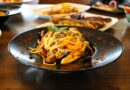 Healthy food concept. Spaghetti with shrimps, prawns and mussels. Blur plates with foods background.