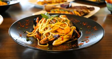 Healthy food concept. Spaghetti with shrimps, prawns and mussels. Blur plates with foods background.