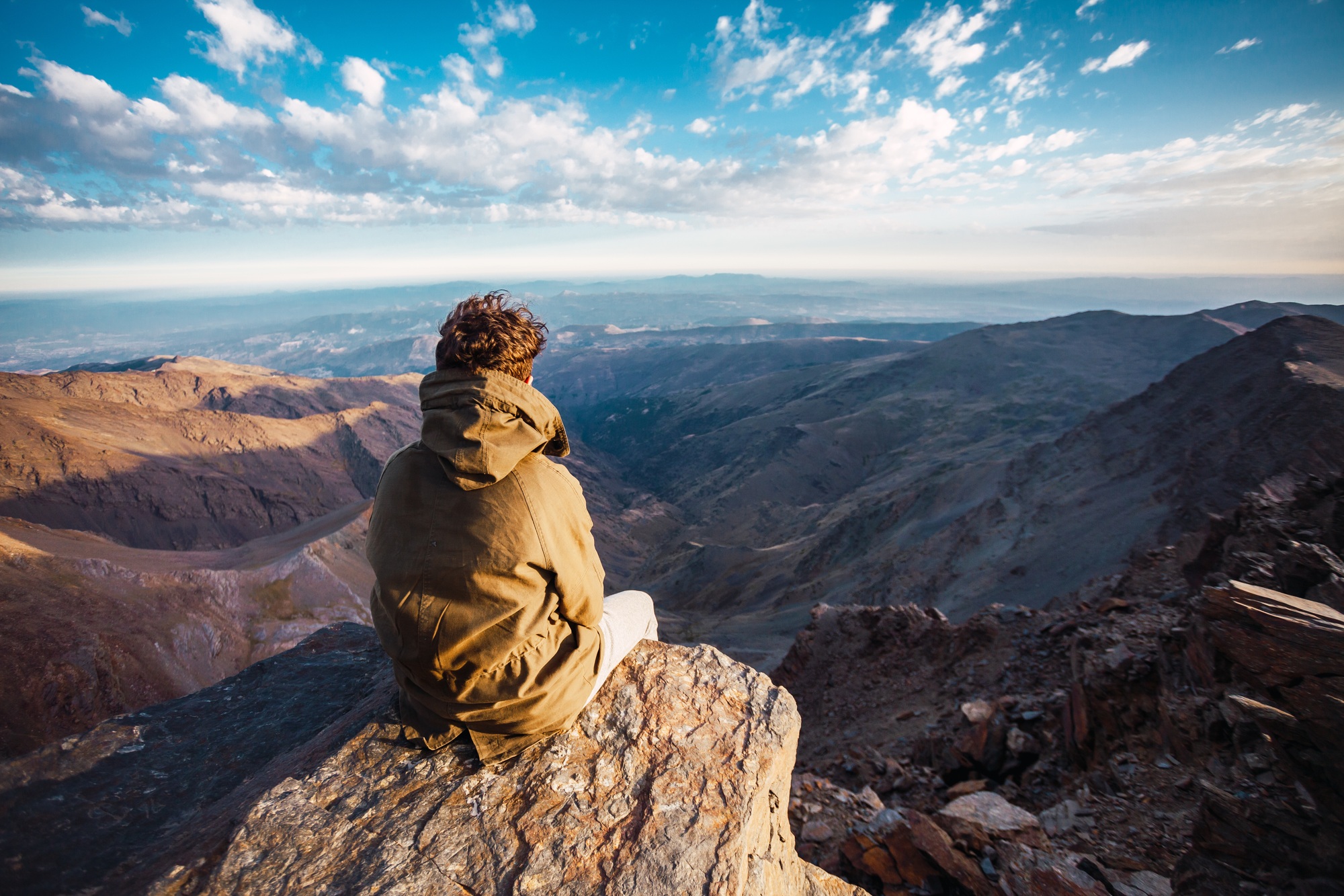 Hiker enjoying a beautiful landscape view from the summit of Mulhacen in Sierra Nevada, Spain