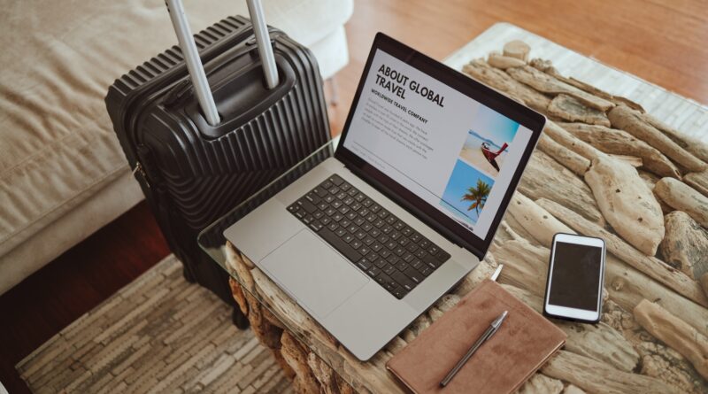 Laptop screen, travel website and suitcase background for vacation planning, hospitality marketing