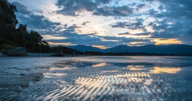 Sunset over Wet Beach in Pohara, Golden Bay, New Zealand