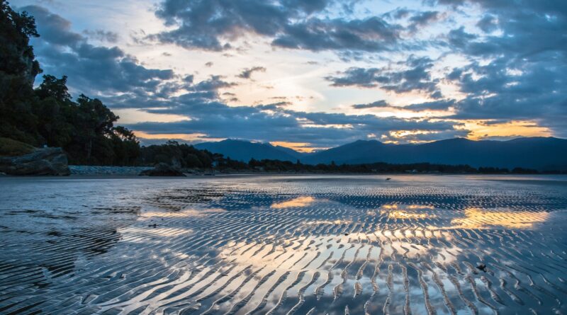 Sunset over Wet Beach in Pohara, Golden Bay, New Zealand
